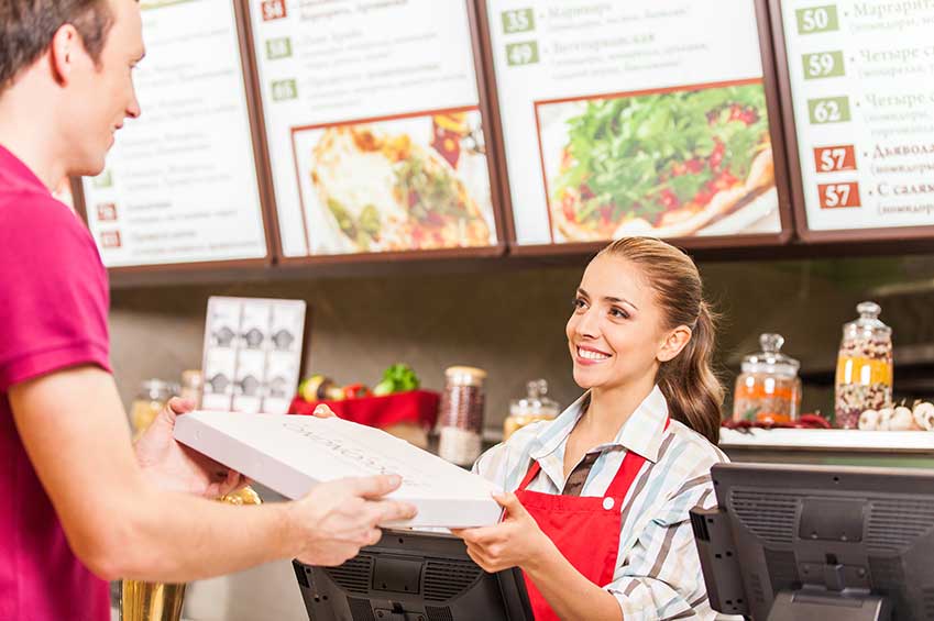 Worker Giving Customer a Pizza