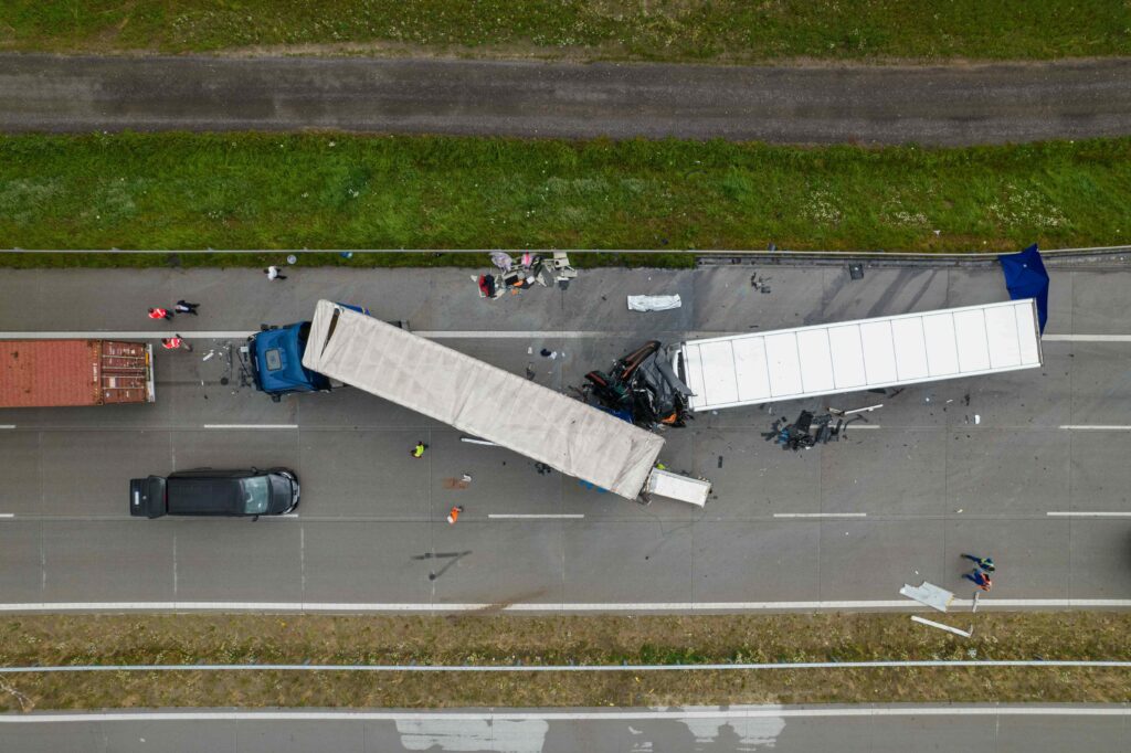 Aerial view of multi-vehicle truck accident on highway with emergency responders, highlighting serious road collision and transportation liability scene Aerial view of multi-vehicle truck accident on highway with emergency responders, highlighting serious road collision and transportation liability scene