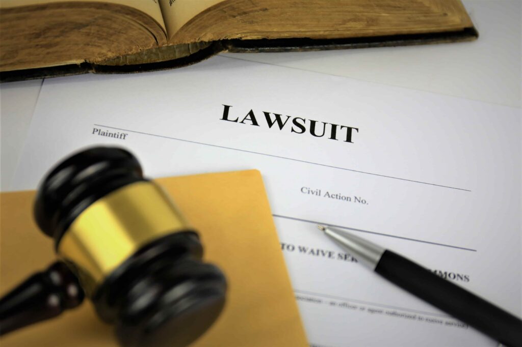 Lawsuit legal document with judge&rsquo;s gavel, pen, and law book representing civil litigation and legal proceedings