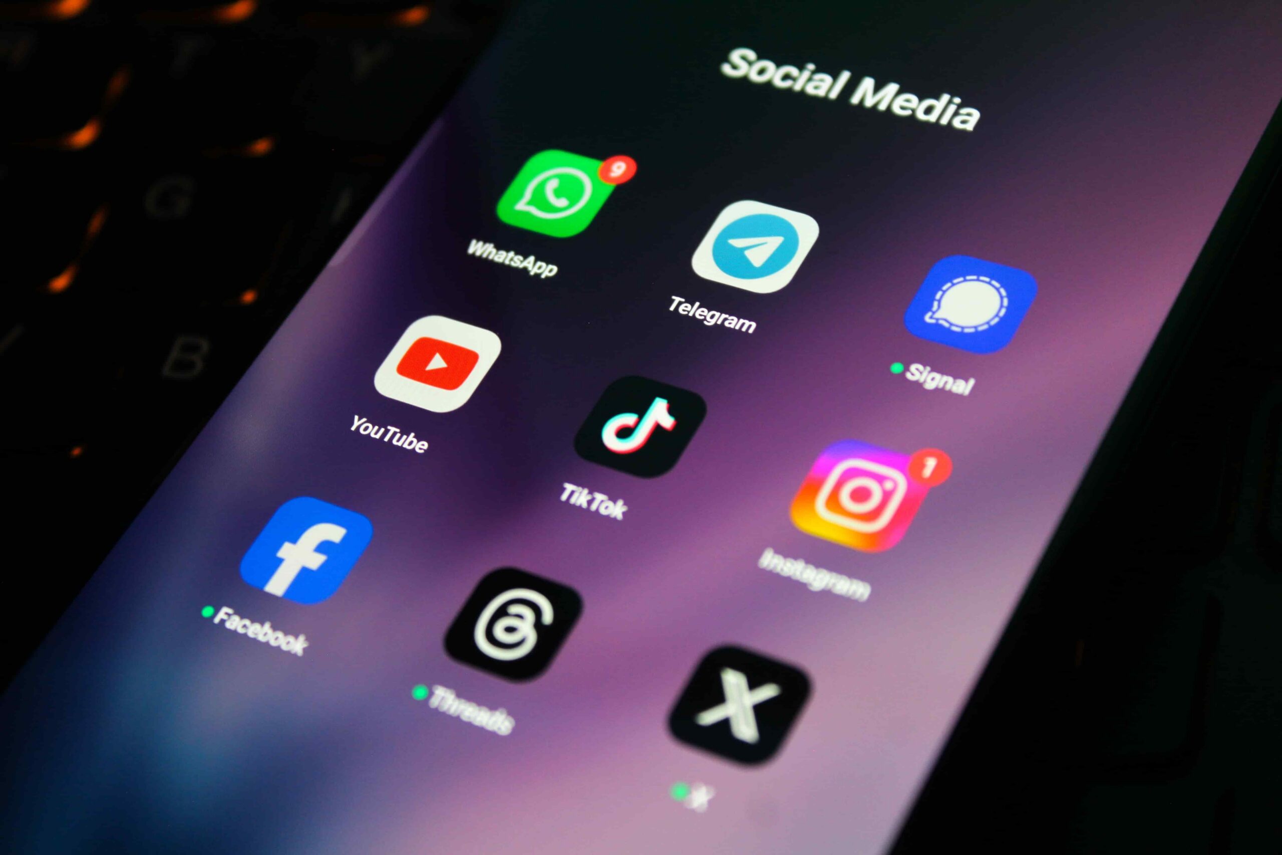 Smartphone screen displaying social media apps including WhatsApp, Telegram, TikTok, Instagram, Facebook, YouTube, and Signal icons
