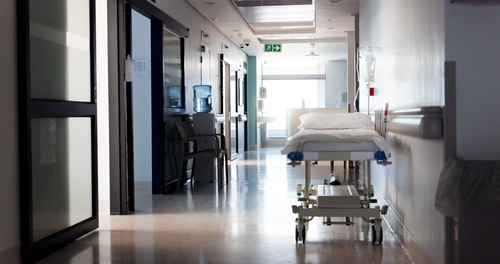 a view of an hospital corridor with movable bed. no people.