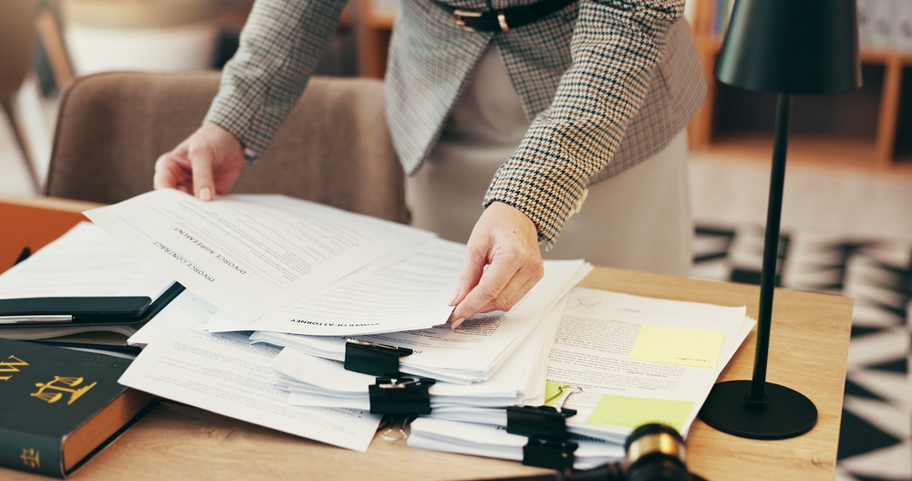 Legal associate researching documents on a desk.