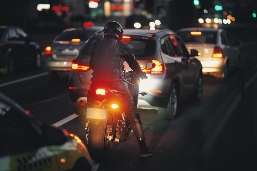 Motorcycle rider in traffic at night