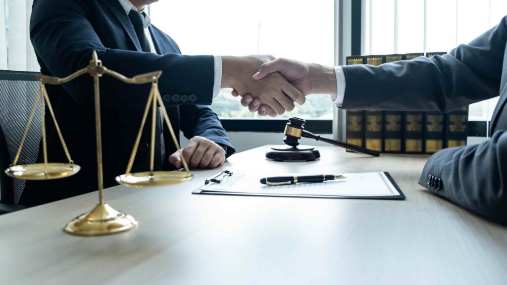 Lawyer and client shaking hands across a desk