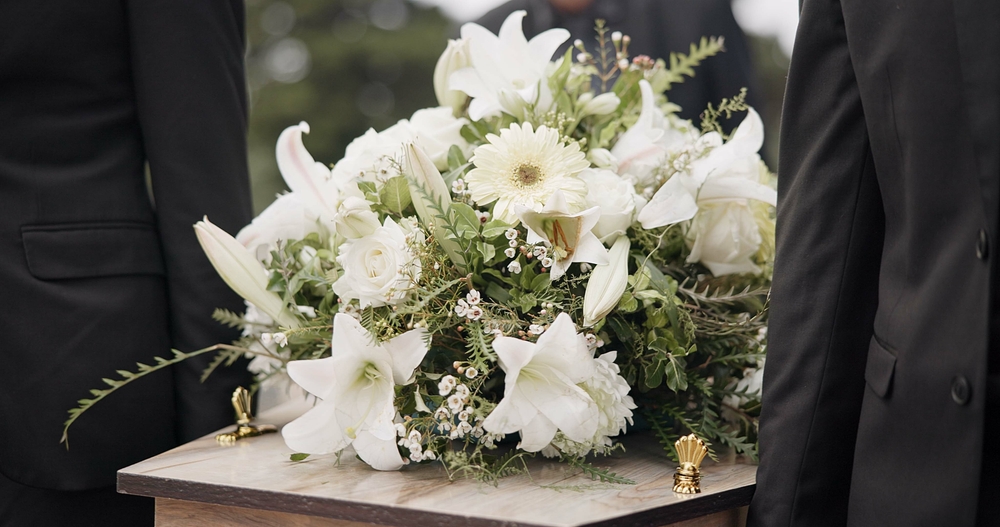 White flower bouquet atop a casket
