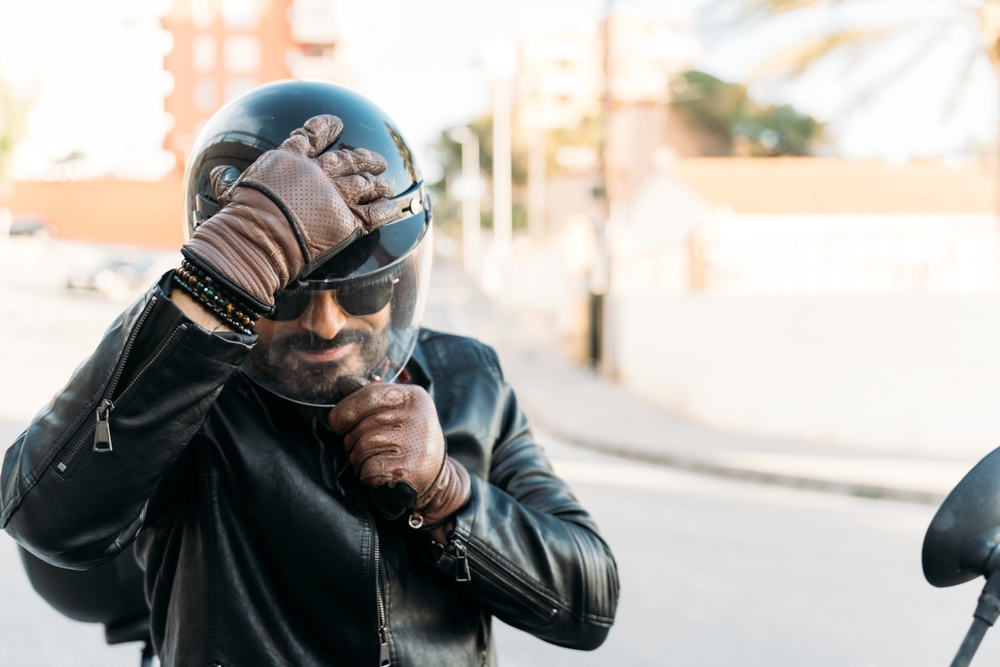Motorcycle rider adjusts his helmet before use