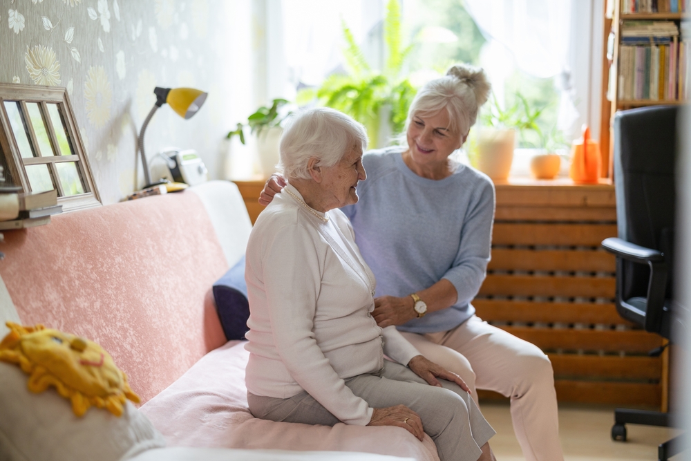 Caregiver provides assistance to elderly woman in home setting